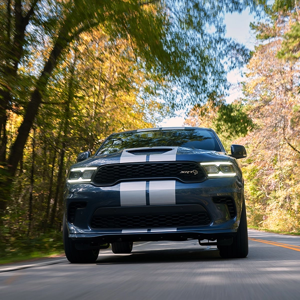 Blue Dodge Durango Hellcat surrounded by trees