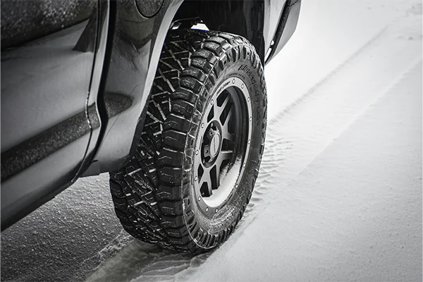 Truck snow tire sitting on snowy road
