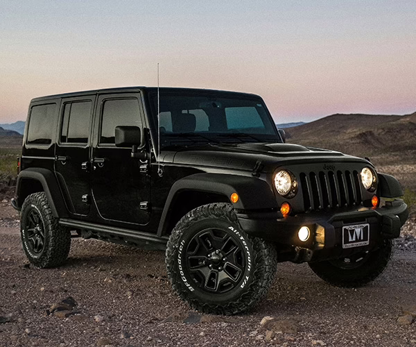 Black jeep parked off road